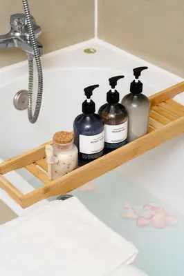 a shelf with four bottles of soap and a sink at Mystic Haven King Bed Suite with Balcony & City Views in Khlong Toei