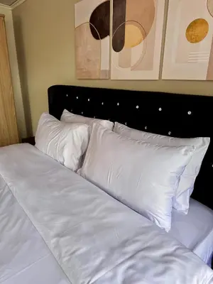 a bed with white sheets and pillows in a bedroom at Urban Grace in Bangkok