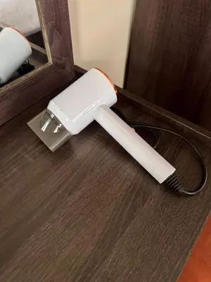 a white blow dryer sitting on a wooden floor at Urban Grace in Bangkok