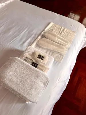 a white bed with two towels on top of it at Urban Grace in Bangkok
