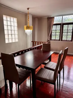 a dining room with a wooden table and chairs at Urban Grace in Bangkok