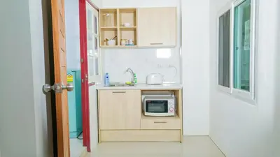 a small kitchen with a sink and a microwave at Studio in townhouse with private bath room and kitchenette in Amphoe Phra Khanong