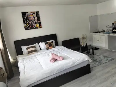 a bedroom with a bed with two pink slippers on it at IMPACT popular condo c5 แม่ตังค์ in Ban Bang Phang