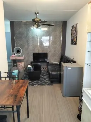 a living room with a couch and a table at IMPACT popular condo c5 แม่ตังค์ in Ban Bang Phang