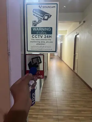 a person is holding a toothbrush in a hallway at Boontorsub in Ban Khlong Samrong