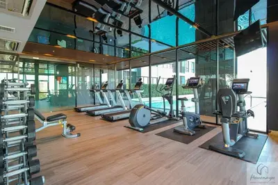a gym with a row of treadmills and machines at 2BR Condo with Oldtown Bangkok Vibes, Steps from Wongwian Yai in Bangkok