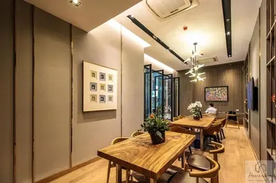 a dining room with wooden tables and chairs at 2BR Condo with Oldtown Bangkok Vibes, Steps from Wongwian Yai in Bangkok