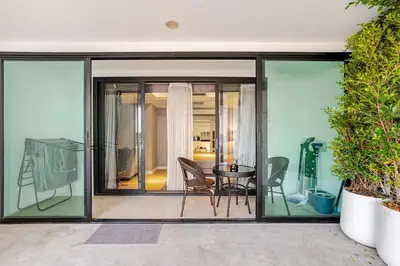 a glass extension of a house with a table and chairs at State tower City view Central River Station in Bangkok