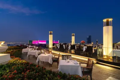 a restaurant with white tables and chairs on a roof at State tower City view Central River Station in Bangkok