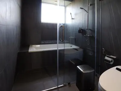 a bathroom with a glass shower and a toilet at Citrus House Phra-Arthit in Bangkok