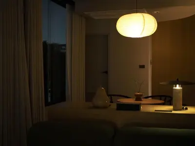 a living room with a table and a lamp at Citrus House Phra-Arthit in Bangkok