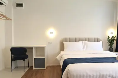 a bedroom with a bed and a chair in it at Yummy House in Bangkok