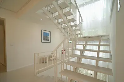 a wooden spiral staircase in a room with a window at Yummy House in Bangkok