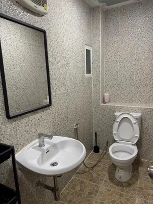 a bathroom with a sink and a toilet and a mirror at WannaB Hostel in Khlong San