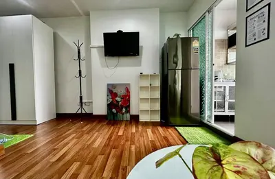 a living room with a refrigerator and wooden floors at Comfy1BR at Bangson byBB in Bangkok