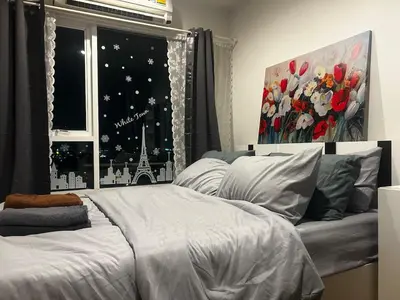 a bedroom with a bed and a window with a view at Comfy1BR at Bangson byBB in Bangkok
