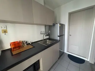 a small kitchen with a sink and a refrigerator at River Cando Perfect for relaxing in Ban Sai Ma