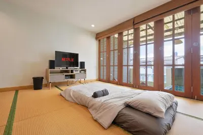a bedroom with a large bed and a tv at Bangkok Japanese designed 3BR Home Ekkamai BTS in Bangkok