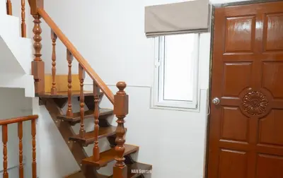 a wooden staircase with a window and a wooden door at Nan Square II in Bangkok