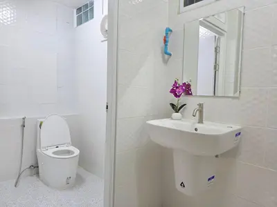 a white bathroom with a sink and a toilet at Nan Square II in Bangkok
