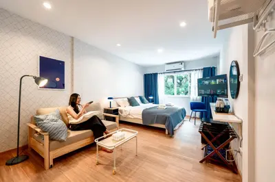 a woman sitting on a couch in a hotel room at Blue House 191 Hometel in Chinatown