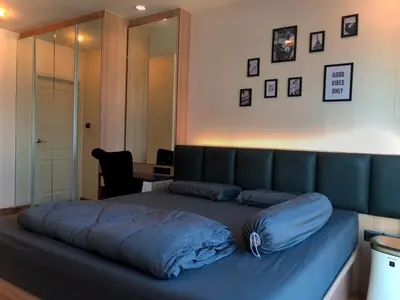 a bedroom with a bed with a blue blanket on it at Supalai Wellington 2 in Ban Na Song
