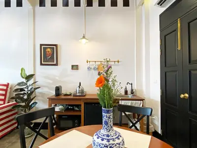 a vase with flowers on a table in a room at Stylist Siamese Design House Steps To Chinatown - Self Check In in Bangkok