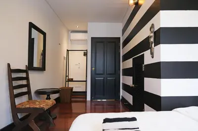 a bedroom with a black and white striped wall at Stylist Siamese Design House Steps To Chinatown - Self Check In in Bangkok