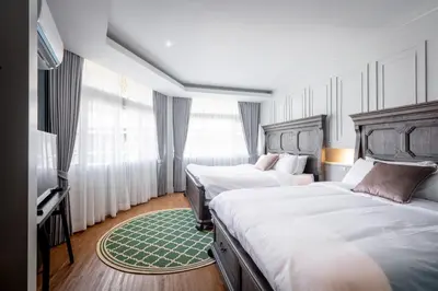 a hotel room with two beds and a television at Lemoncurd Bread and Coffee in Bangkok