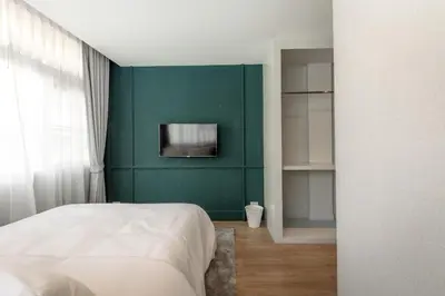 a bedroom with a green wall and a bed at Lemoncurd Bread and Coffee in Bangkok
