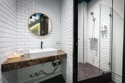 a white bathroom with a sink and a mirror at Lemoncurd Bread and Coffee in Bangkok