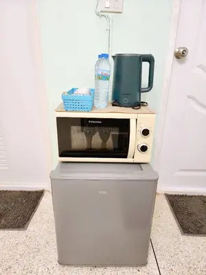 a microwave oven sitting on top of a refrigerator at 808-STP Homely room Free Wi-Fi and Near BTS in Sathani Bang Khen
