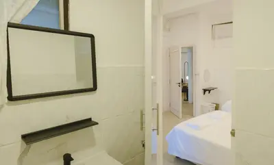 a white bathroom with a mirror and a sink at 2 BR Sleeps6 I City Center Silom in Bangkok