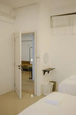 a white room with a bed and a table at 2 BR Sleeps6 I City Center Silom in Bangkok