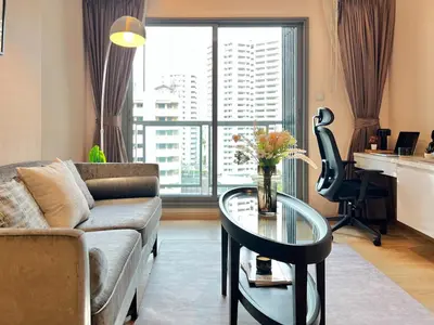 a living room with a couch and a table at Stylish Modern 1BR - Ultra Fast Wifi - BTS Phrom Phong in Bangkok