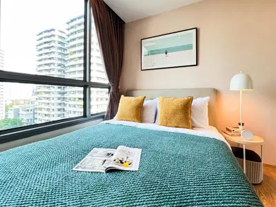 a bedroom with a bed with a newspaper on it at Stylish Modern 1BR - Ultra Fast Wifi - BTS Phrom Phong in Bangkok