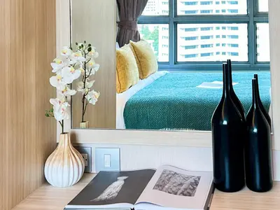 a bedroom with a bed and two bottles and a book at Stylish Modern 1BR - Ultra Fast Wifi - BTS Phrom Phong in Bangkok