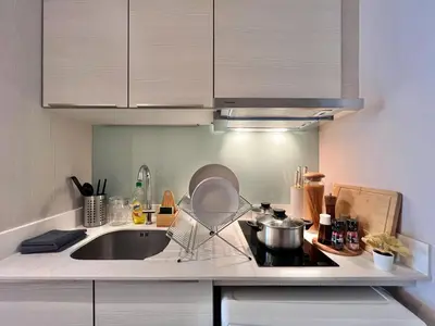 a kitchen with a sink and a pot on the stove at Stylish Modern 1BR - Ultra Fast Wifi - BTS Phrom Phong in Bangkok