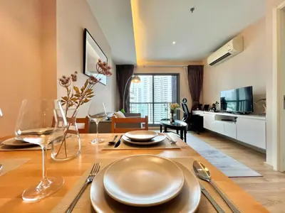 a living room with a table and a dining room at Stylish Modern 1BR - Ultra Fast Wifi - BTS Phrom Phong in Bangkok