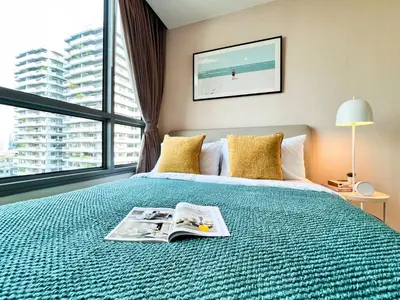 a bedroom with a bed with a magazine on it at Stylish Modern 1BR - Ultra Fast Wifi - BTS Phrom Phong in Bangkok