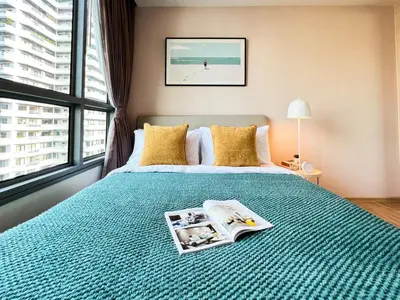 a bedroom with a bed with a book on it at Stylish Modern 1BR - Ultra Fast Wifi - BTS Phrom Phong in Bangkok
