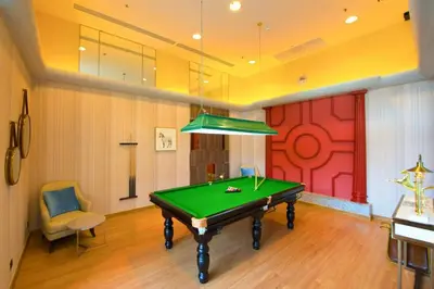 a pool table in a room with a red wall at คอนโดศุภาลัยเวลลิงตัน2 in Bangkok