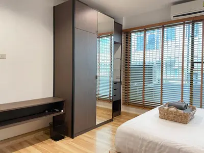a bedroom with a bed and a large window at Vélin - Samsen in Bangkok