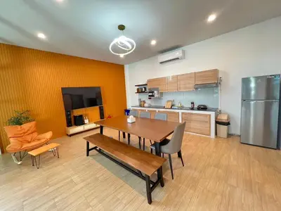 a living room with a table and a kitchen at นวมินทร์ 76 พูลวิลล่า - Nawamin 76 Poolwilla in Ban Baen Phichit