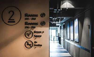 a hallway with signs on the wall in a building at THA City Loft by TH District in Bangkok