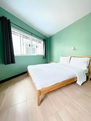 a bedroom with a large bed and a green wall at xxGO INN The Giant Swing - เสาชิงช้า in Bangkok