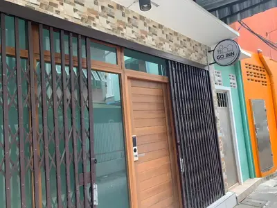 a wooden door of a building with a sign on it at xxGO INN The Giant Swing - เสาชิงช้า in Bangkok