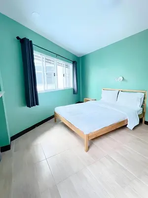 a bedroom with a large bed and a blue wall at xxGO INN The Giant Swing - เสาชิงช้า in Bangkok
