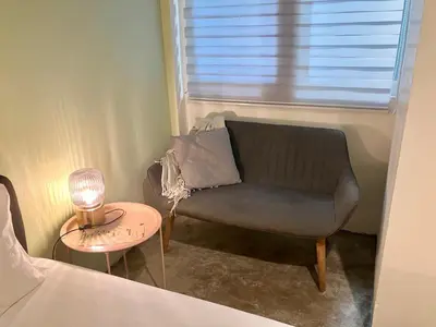 a chair in a room with a lamp and a table at 326 Podtel at The Breakie Bar in Bangkok