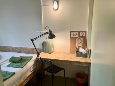 a bedroom with a desk with a bed and a chair at 326 Podtel at The Breakie Bar in Bangkok